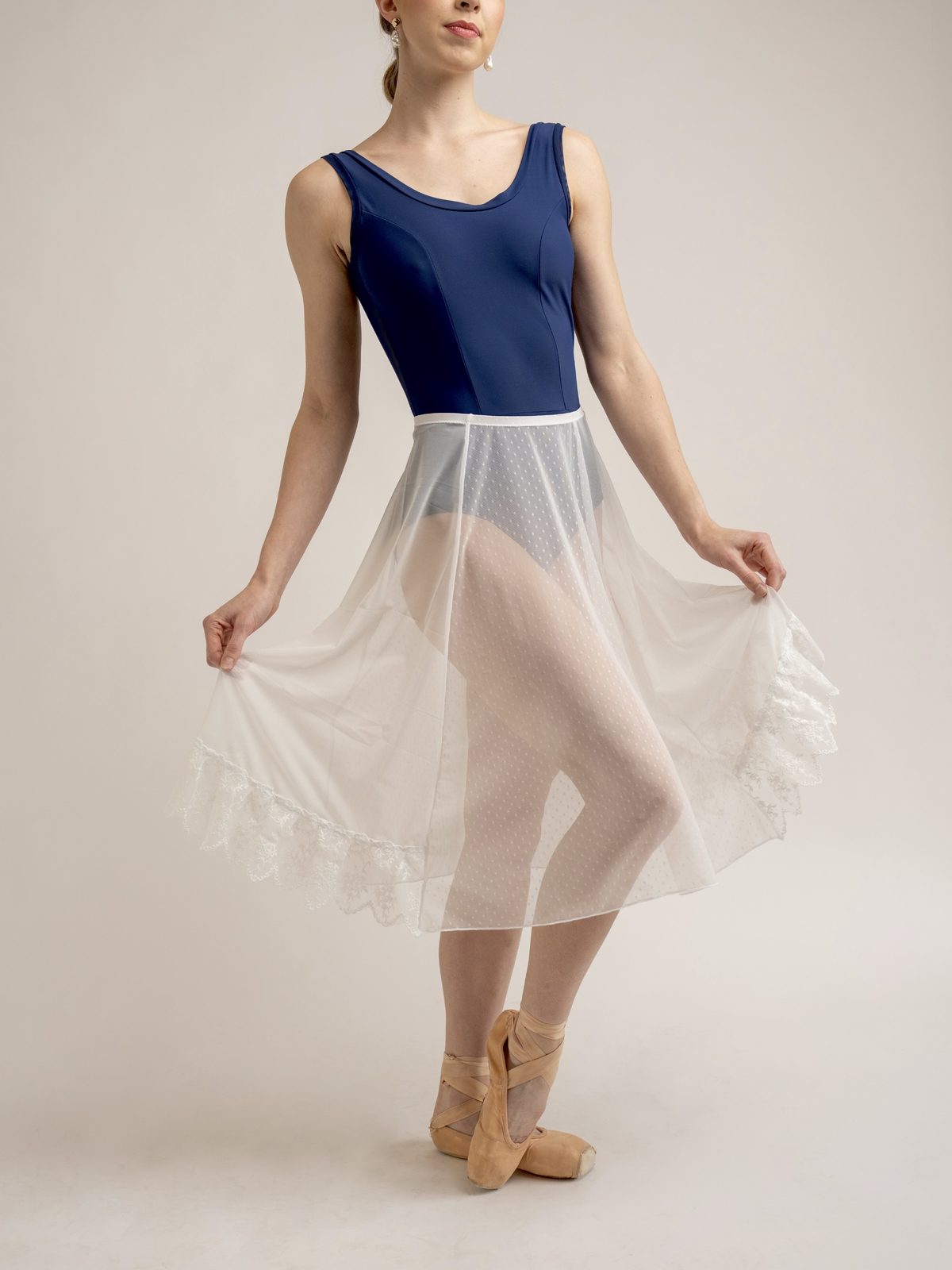 Dancer holding an ivory skirt with lace hem
