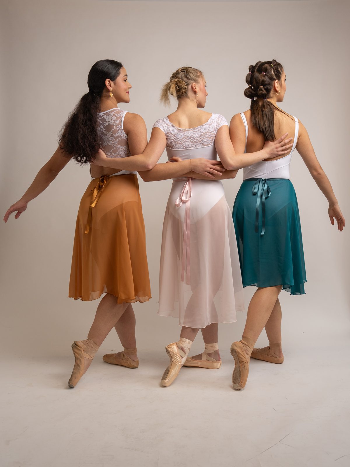 Three dancers in handmade skirts standing together