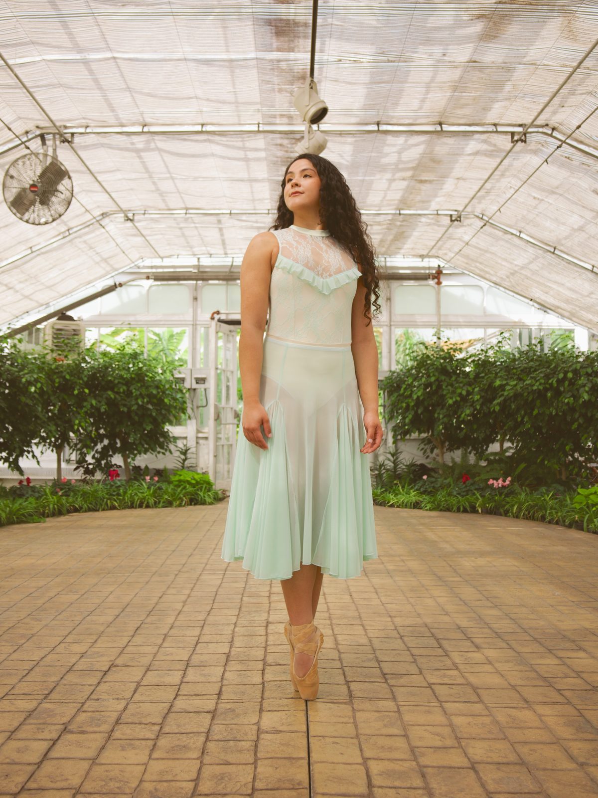 Dancer standing beneath the greenhouse canopy