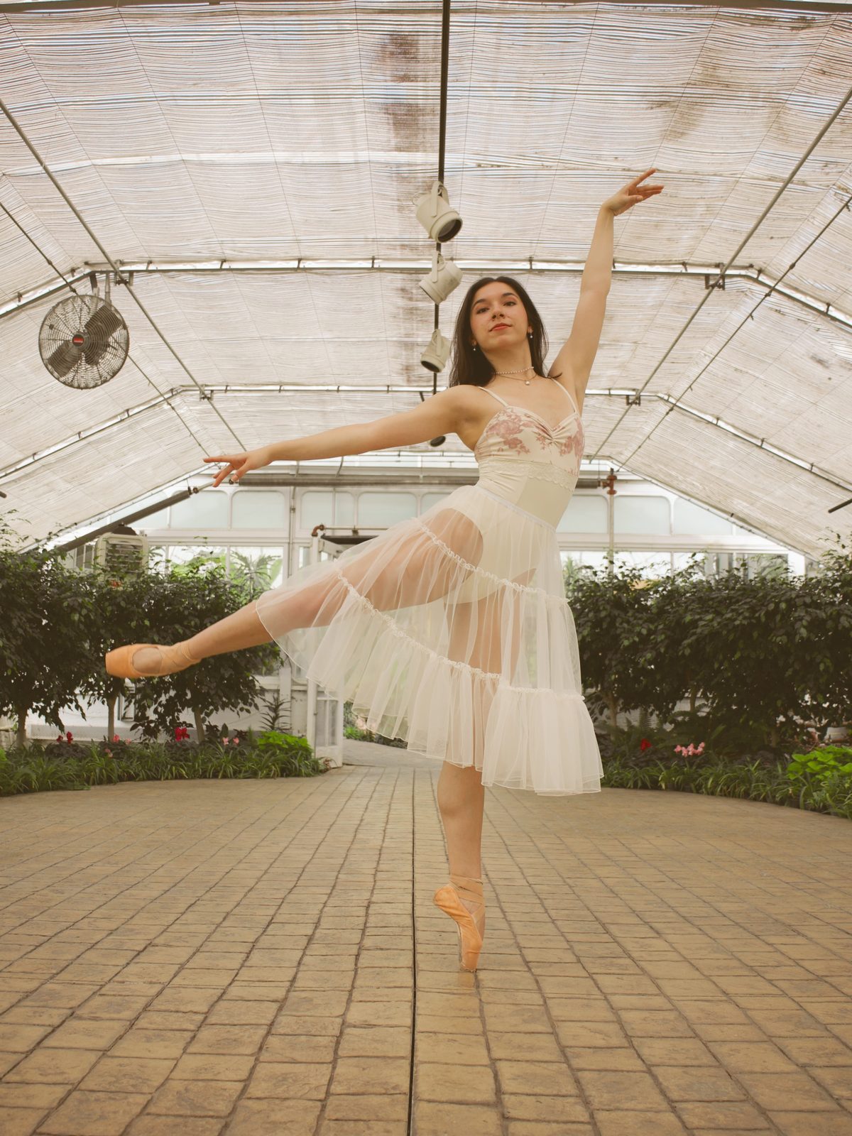 Dancer mid-kick in white tulle