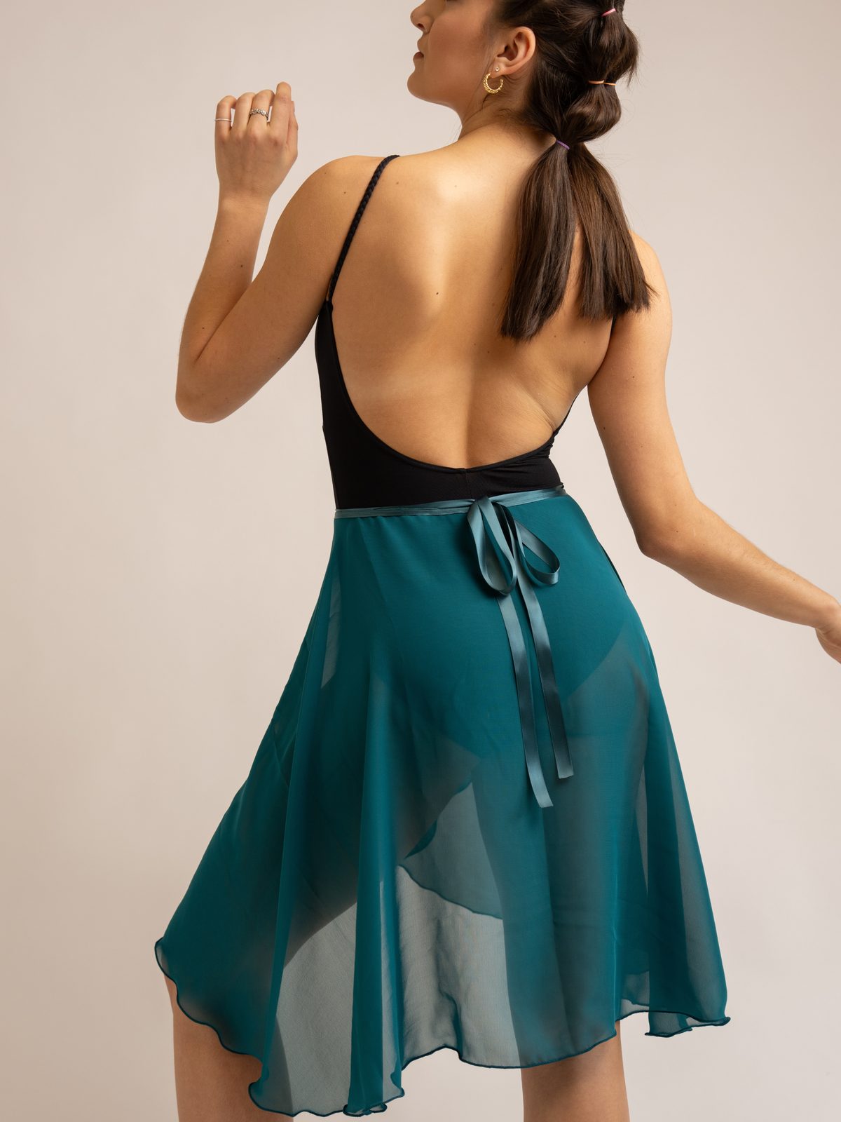 Detail of a teal wrap skirt tied with a ribbon bow