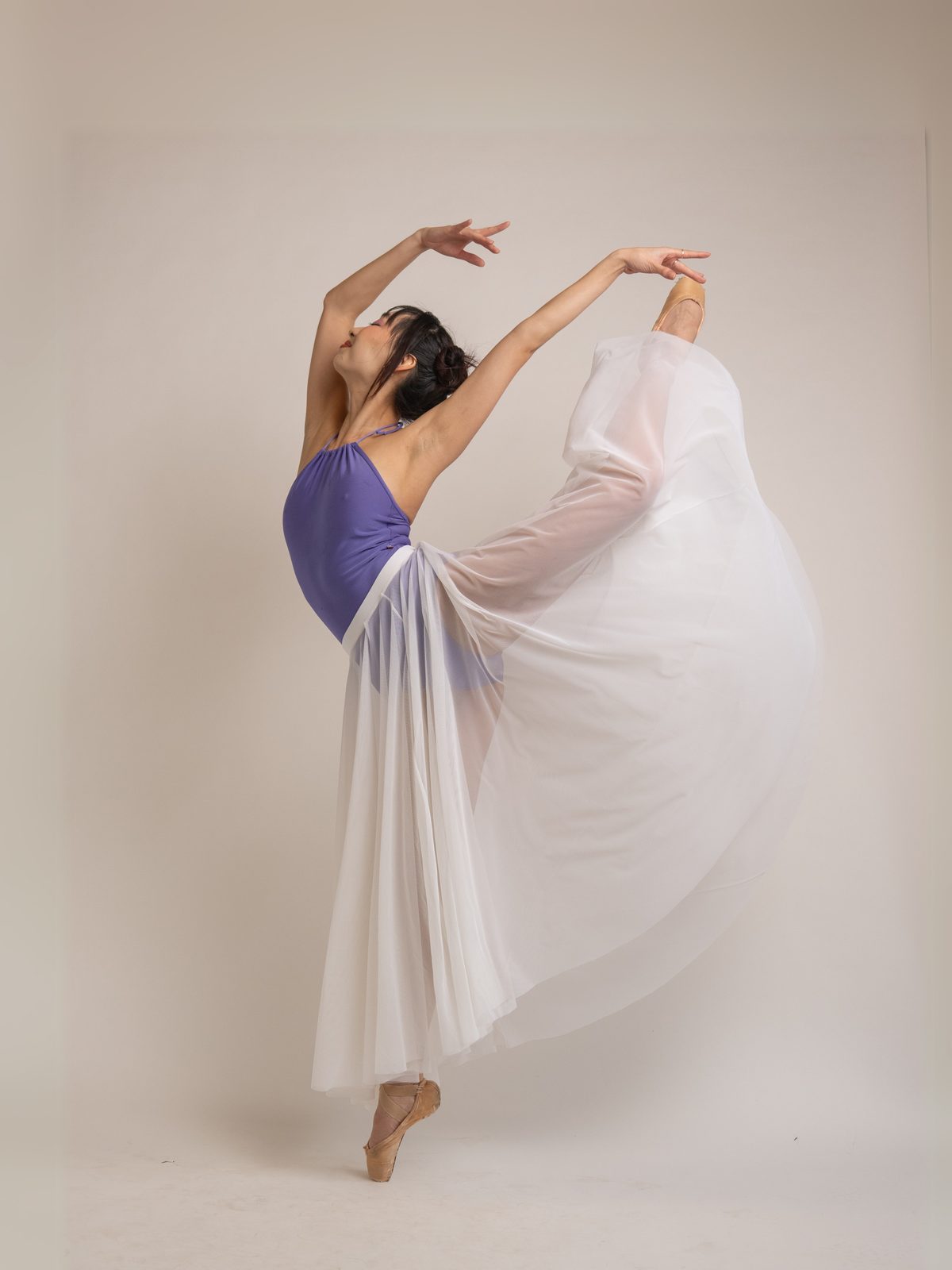 Dancer in a flowing white skirt, arms raised